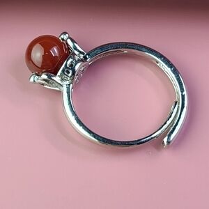 Silver tone adjustable ring with a movable red stone size 7.5